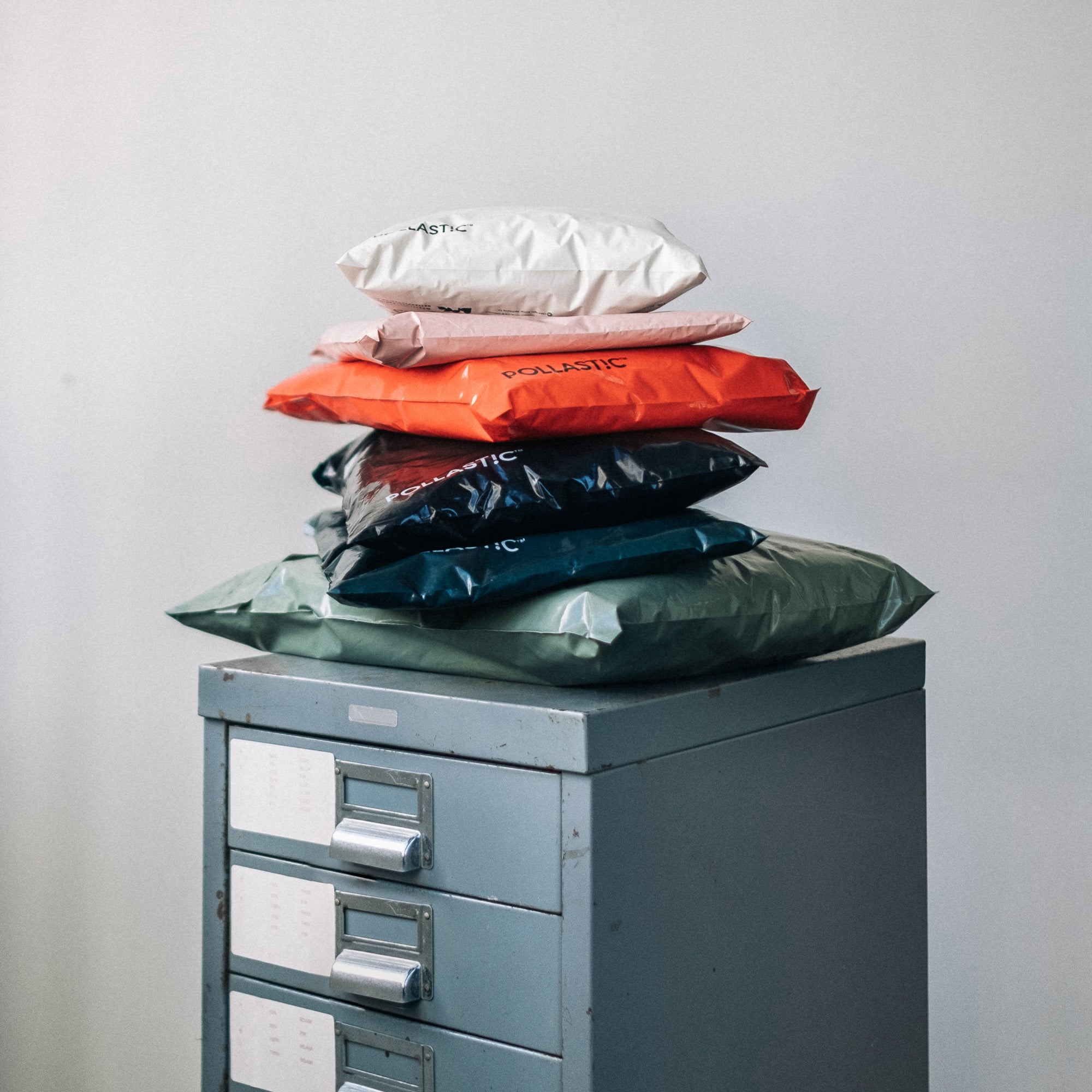 Stack of POLLAST!C Mailers on a filing cabinet