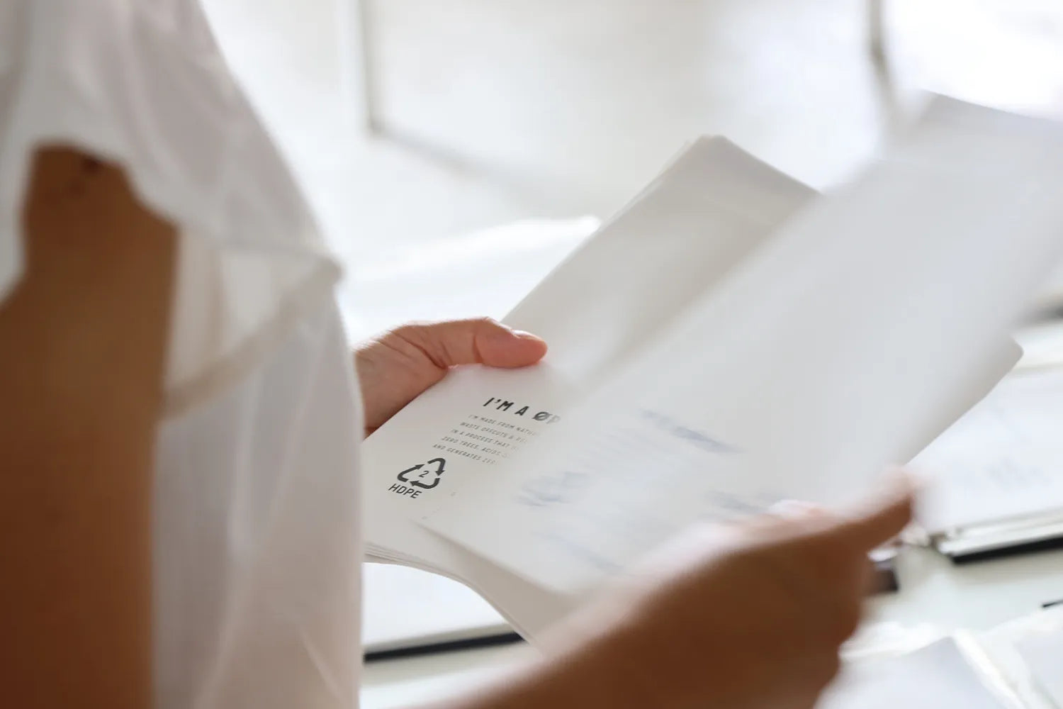 Person holding a white product with a label, blurred background