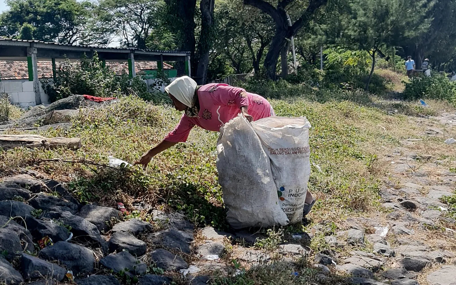 Person working with a large stone in an outdoor setting